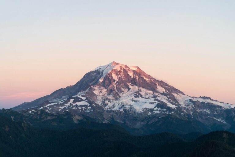 A snowy Washington mountain is highlighted by the bright hues of sunset.