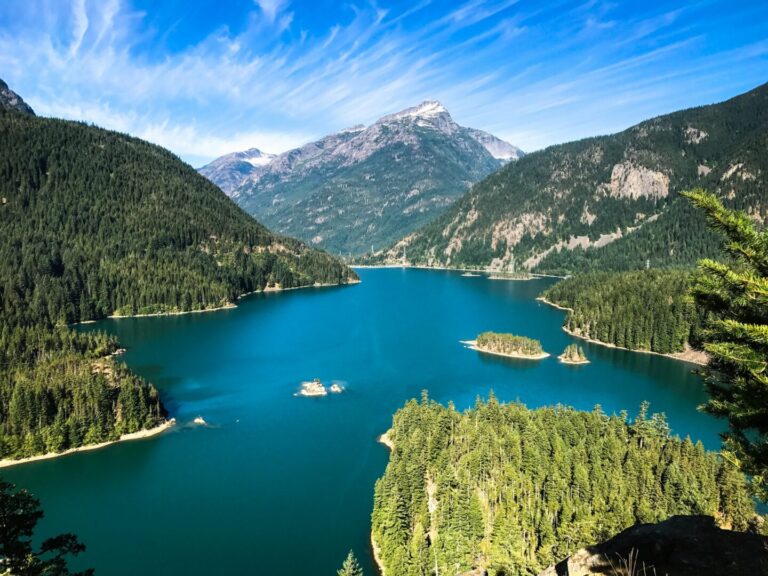 A beautiful photograph of lush mountains encircling a tranquil blue lake.